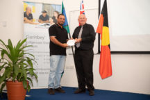 Caine receives his award from CDU Vice-chancellor, Scott Bowman, at the CDU Indigenous Valedictory Celebration.